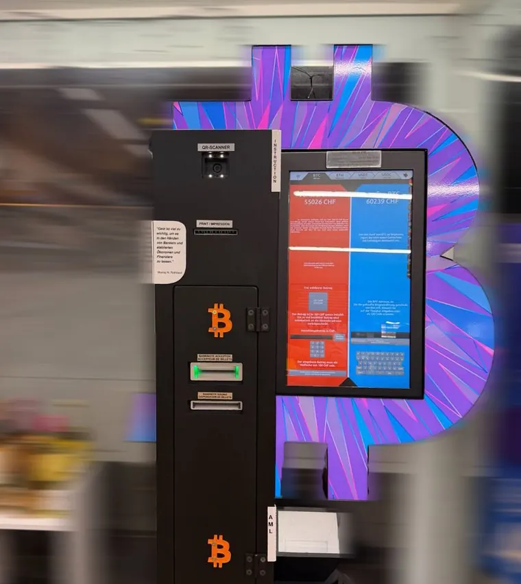 Bitcoin ATM at Feldbergstrasse 100 in Basel with a purple Bitcoin backdrop.